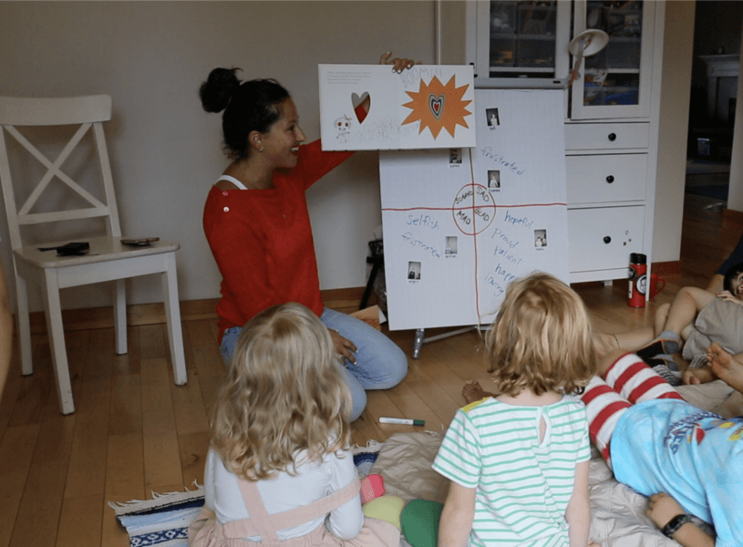 teahcer and children looking at feelings chart and book