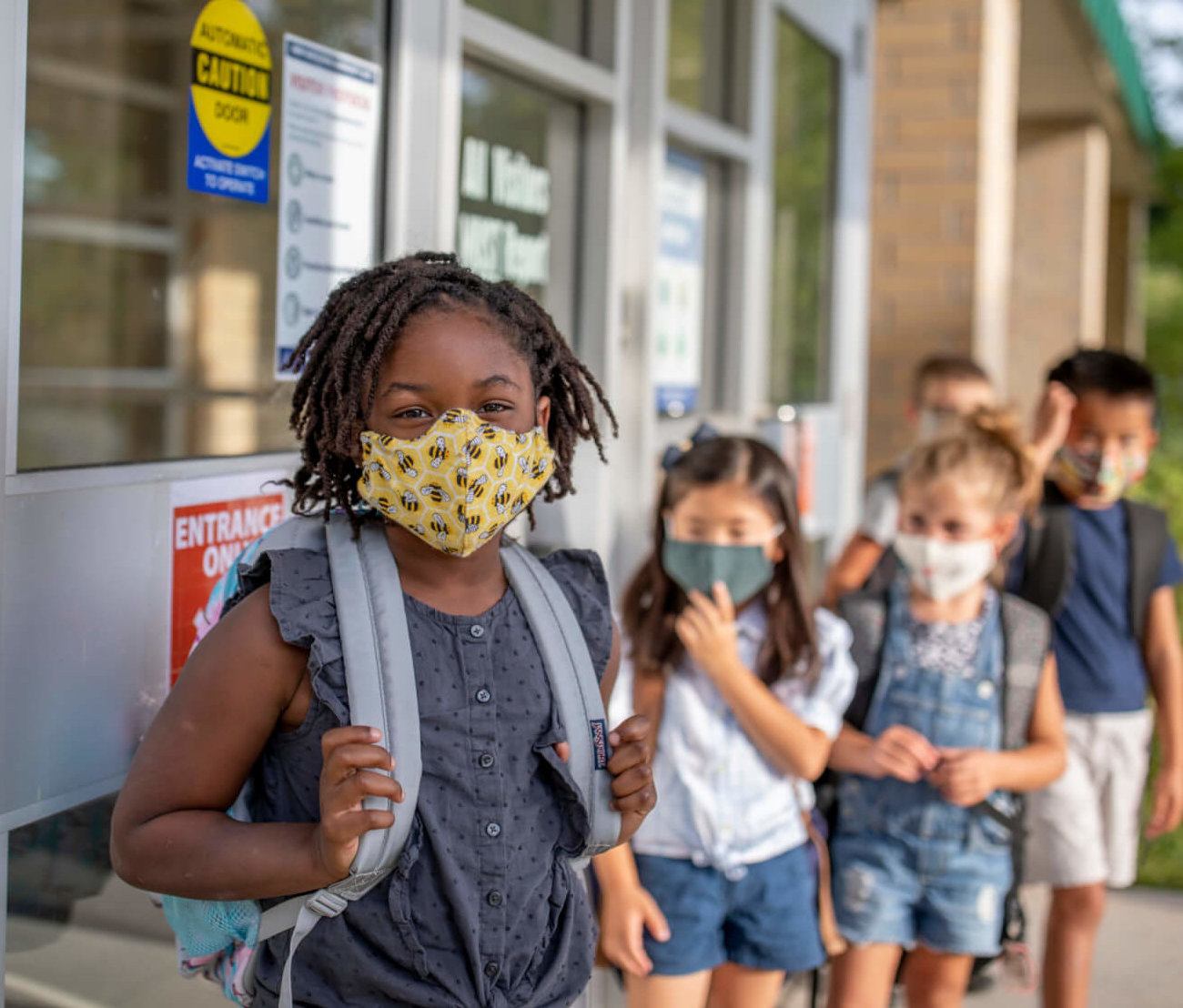 Diverse Group of kids return to school during the pandemic.